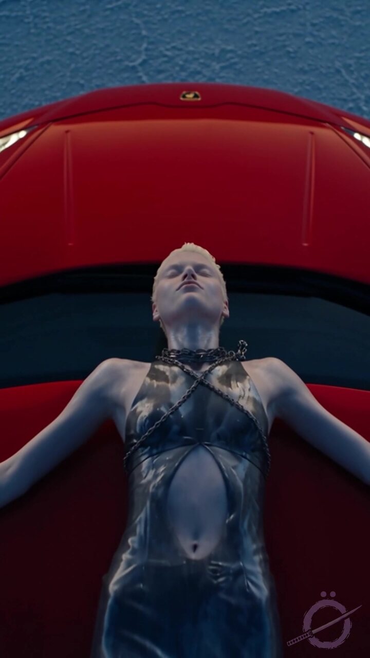 La Reina tumbada sobre el capó rojo