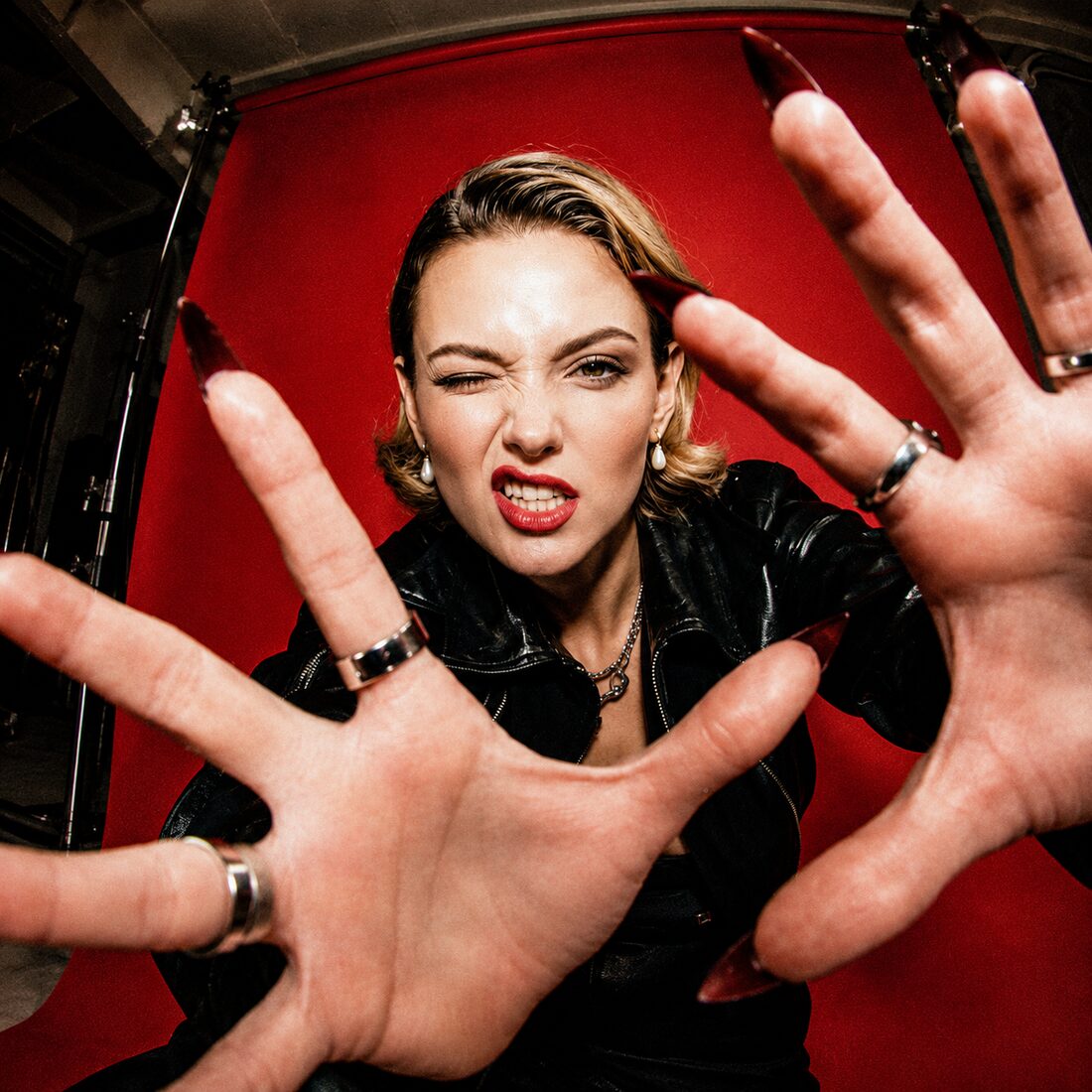 Hands reaching to camera on a crimson background